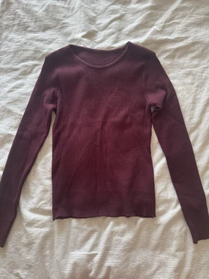 Vinröd ribbstickad tröja - Mysig vinröd ribbstickad tröja som är jätte skön. Tröjan har en slim fit passform och är perfekt för lager på lager. Materialet är mjukt och stretchigt, vilket gör den bekväm att bära hela dagen. Säljer för att den var lite för stor. den passar S/M