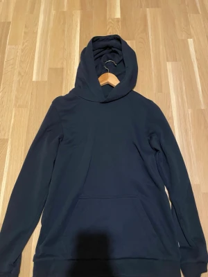 Blå hoodie från Jack & Jones - Mörkblå hoodie ifrån Jack and Jones som har en luva och ficka i mitten. Sitter bra för en person med storlek S och XS