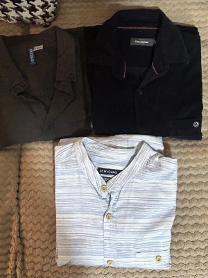3-pack skjortor i olika färger den uppe till höger är T-shirt skjorta - Säljer ett 3-pack skjortor: en svart, en mörkgrön och en ljusblåvit randig henley från LCW Young. Skjortorna har klassisk krage och knappar framtill. Perfekt för dig som vill variera stilen med både enfärgat och mönstrat.