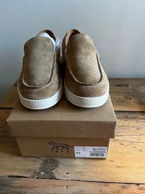 Tiger of Sweden loafers Mocha - Snygga loafers i beige mocka med vit, tjock sula. Skorna har en stilren och enkel design utan snörning, perfekt för en avslappnad men trendig look. Passar dig som gillar klassiska och bekväma skor med modern touch. Kartonger är inkluderat! Säljer dessa på grund av att jag fick fel storlek! 