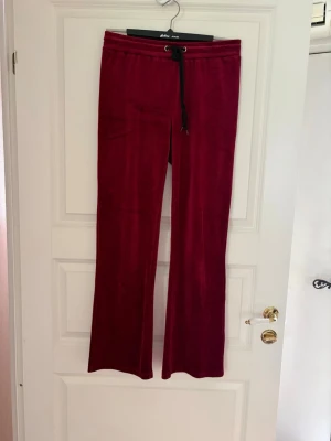 Vinröda mjukisbyxor i velour - Säljer ett par vinröda mjukisbyxor i mjuk velour med raka ben och svart dragsko i midjan. Byxorna har en avslappnad passform och resår i midjan för extra komfort. Perfekta för chill dagar eller när du vill vara extra bekväm. Kolla gärna mina andra annonser❗️