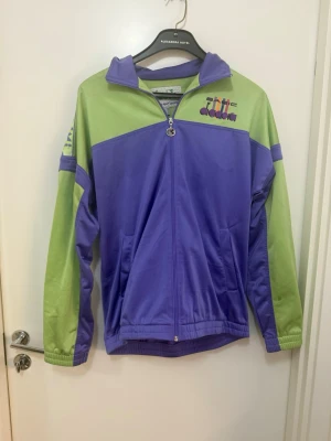 Vintage  träningsjacka från Diadora Y2K L / XL  - Snygg retro träningsjacka från Diadora. Tillverkad i ett mjukt syntetmaterial som passar perfekt till sport eller streetwear.den är rymlig så den passar även folk med Xl