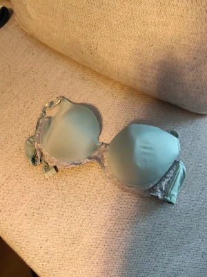 Ljusgrön bh med spetsdetaljer - Snygg ljusgrön bh med vadderade kupor och fina spetsdetaljer längs kanterna. Bh:n har justerbara axelband och bygel för extra stöd. Materialet är slätt och mjukt, vilket ger en bekväm känsla hela dagen.