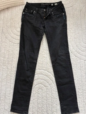 Svarta miss me jeans - Säljer ett par svarta skinny jeans med snygga detaljer vid fickorna. Dom är mid-rise och i storlek 27