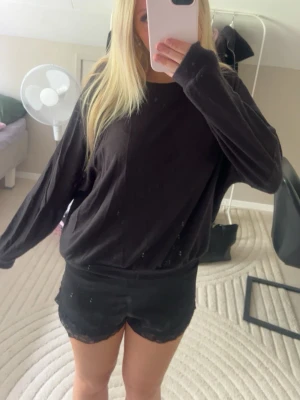 Svart sweatshirt - En svart sweatshirt med rund halsringning och långa ärmar. Tröjan har en avslappnad passform och är tillverkad i mjukt material, perfekt för en chill och enkel stil. Passar till det mesta och är superbekväm.