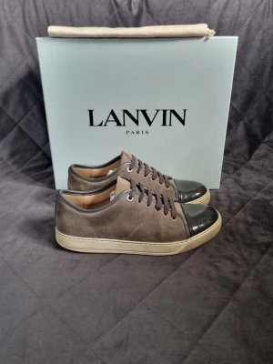 Lanvin - Lanvin Cap Toe sneakers | Storlek: Uk 6 fits 39-40 | Skick: 7,5/10 | Skorna behövs endast tvättas | Tillkommer: Box, nya skosnören och en dustbag | Färg: grå | Nypris: 4999kr | Vårt pris: 1699 kr | Bara att skriva om du har några funderingar! | Välj helst Bring som leveransmetod, eftersom jag bor bredvid en Bring box! Då går leveransen 100 % snabbare, Instabox funkar också!