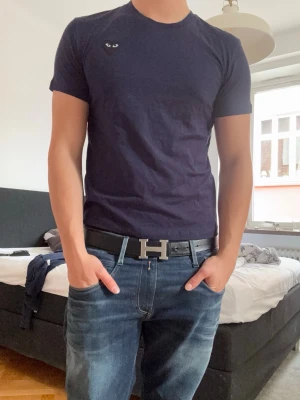 Mörkblå cdg t-shirt - Snygg mörkblå cdg t-shirt. Passformen är normal och materialet känns mjukt och bekvämt, troligtvis bomull. Perfekt till jeans eller shorts.                                                                  Kom pm för frågor!’