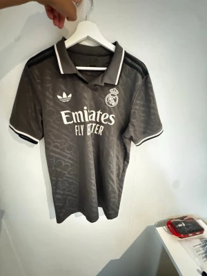 Real Madrid 3:e-tröja - Köpt i våras och kom aldrig till användning pga för liten storlek. Storlek M med slim passform så rekommenderas till dig som är mindre i överkroppen.