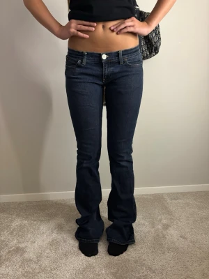 Lågmidjade bootcut jeans - Mörka lågmidjade jeans, dom är lite slitna nere vid hällarna på båda sidorna men annars jättefint skick🥰🥰