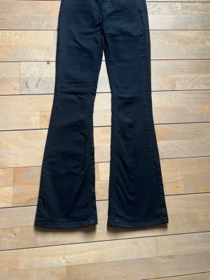 Svarta högmidjade bootcut jeans - Snygga svarta jeans med bootcut-modell. Tillverkade i ett stretchigt denimtyg för skön passform. De har vissa tecken på användning och säljs däroch med för ett billigt pris!