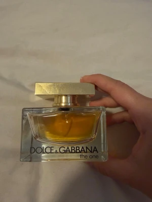 Dolce & Gabbana The One parfym - Säljer en lyxig parfym från Dolce & Gabbana, The One. Doften är en lyxig och sofistikerad designad för den moderna kvinnan som utstrålar självförtroende och charm. Denna varma, orientalisk-blommiga doft öppnar med gnistrande noter av bergamott, mandarin, litchi och persika, vilket skapar en inbjudande och lysande introduktion.