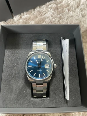 GANT silverfärgad klocka blå urtavla - Stilren klocka från GANT med silverfärgad länk i metall och blå urtavla. Klockan har datumvisning och tydliga markeringar. Kommer med originalbox, extra länkar, kvitto och tag. Nypris är 4800 kr. Pris kan såklart diskuteras och bara höra av dig om du har någon fråga!😁