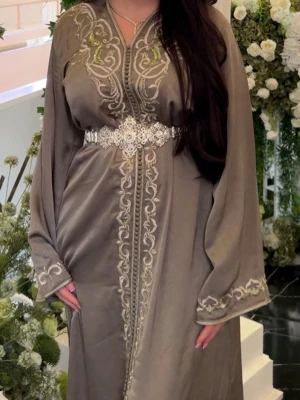 Kaftan - Exklusiv handsydd marockansk kaftan i pistagegrön färg med vackra handbroderade detaljer. Använd vid endast ett event, nyskick. Storlek S men passar XS-M då den kan knytas åt efter behov. Matchande silvrigt bälte ingår. Bältet har släppt på ena sidan och behöver lagas. Perfekt till bröllop, förlovningsfest, henna, eid eller andra festliga tillfällen.