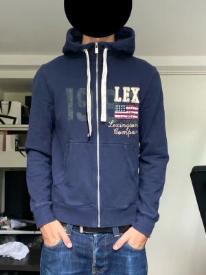 Lexington zip-hoodie - En riktig snygg zip hoodie från lexington i storlek M. Men skulle säga att den sitter mindre. Han på bilden är 178 cm. Snyggt tryck och detaljer i gott skick. Har du funderingar? Fråga på!