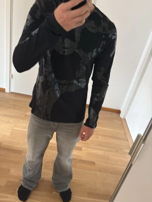Svart långärmad topp med mönster - Säljer en svart långärmad topp från Lee med abstrakt grått mönster. Toppen har en normal passform. 