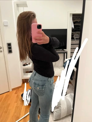 Ljusblå True Religion jeans - Säljer ett par ljusblå jeans från True Religion med klassiska sömmar och fickor med lock och knapp bak. Jeansen har en slim fit-modell och är tillverkade i denim med en snygg tvätt❣️