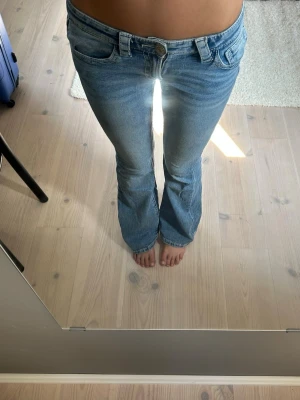 Ljusblå bootcut jeans - Säljer ett par ljusblå bootcut jeans från Gina tricot och låg midja. Jeansen har utsvängda ben och snygga detaljer på bakfickorna. Perfekta för dig som gillar en avslappnad men trendig stil.