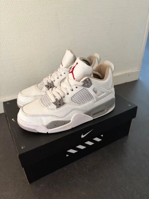 Air jordan 4 Retro white oreo  -  Ny pris 6600!!! 100% äkta Snygga vita Air Jordan 4 Retro sneakers med grå och svarta detaljer samt röd Jumpman-logga på plösen. Skorna har meshpaneler på sidorna, synlig Air-sula och klassisk Jordan-design. Perfekta för dig som vill ha en ikonisk och stilren sneaker.