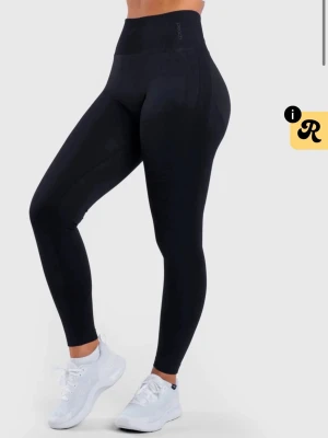 Svarta leggings från Peach Athletics - Snygga svarta leggings från Peach Athletics med hög midja och tight passform. Perfekta för träning eller chill, tillverkade i stretchigt material som formar sig efter kroppen. Diskret logga vid linningen och mjuk känsla. 