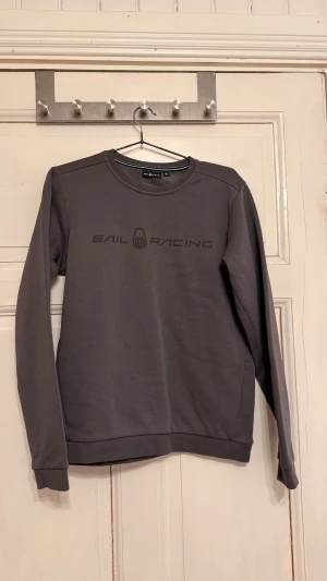 Mörkgrå Sail Racing hoodie - Snygg mörkgrå hoodie från Sail Racing 