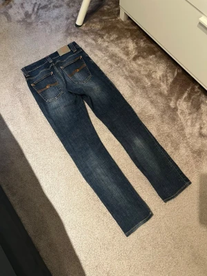 Nudie Jeans - Säljer ett par nudie jeans i modellen grim tim. Jeansen har en sjukt snygg design och är i ett mycket bra skick. Just denna modell är mycket svår att få tag på…⭐️Kontakta vid minsta fundering!