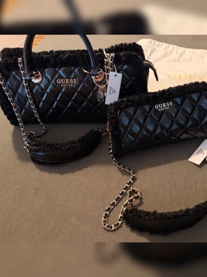 GUESS väskor set – 2 st, helt nya med prislapp  - Säljer ett superfint set från GUESS med två matchande svarta väskor. 🖤  • Helt nya och oanvända • Med prislappar kvar • En större handväska + en mindre matchande väska • Dustbag ingår