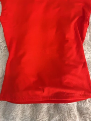 Röd ärmlös topp  - Snygg röd topp med ärmlös design och enkel, stilren look. Toppen har en mjuk och stretchig passform som sitter bekvämt mot kroppen med öppen rygg 