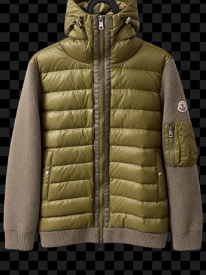 Olivgrön Moncler cardigan  - Snygg olivgrön Moncler med stickade ärmar och vadderad kropp. Jackan har huva, dragkedja framtill, fickor med tryckknappar och en ärmficka med Moncler-logga. Perfekt för kalla dagar och riktigt trendig look.