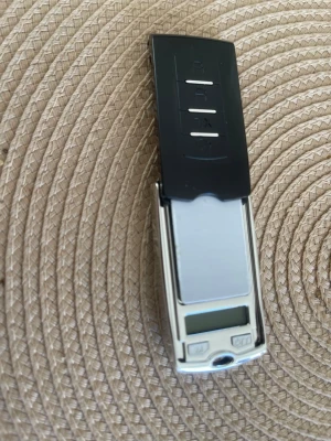 Elektronisk fickvåg digital - Smidig elektronisk fickvåg med digital display och skyddande lock. Perfekt för att väga småsaker som smycken eller mynt. Fickvågen är silverfärgad med svart lock och har tydliga knappar för enkel användning.