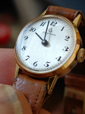 Certina klocka med brunt läderband - Stilren automatisk Certina armbandsklocka med rund vit urtavla, svarta siffror och guldfärgat boett. Vill inte starta. Klockan har ett klassiskt brunt läderband med håldetaljer och enkel knäppning. Perfekt accessoar för dig som gillar tidlös design. 