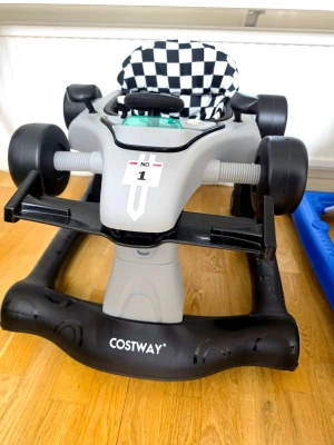 Gåstol i bilmodell från Costway Walker - Säljer en grå och svart gåstol formad som en racerbil med ratt och detaljer som liknar en cockpit. Sitsen har ett schackrutigt mönster i svart och vitt. Perfekt för små barn som vill utforska hemmet på ett roligt sätt. Använd 2 ggr för 2 min kanske. Sonen var inte redo för denna. Nypris 1600.
