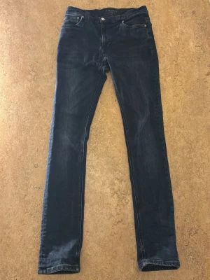 Mörkblå jeans nudie jeans - Säljer dessa feta mörkblåa nudie jeans. det är storlek 30 i midjan och 32 i längden(är lite mindre för sin storlek). Jeansen är använda några gånger men har inga defekter alls