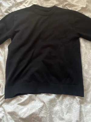 stickad tröja från sayless  - passar dig som är 150-160 svart helt ny En enkel och stilren svart stickad tröja med rund halsringning och ribbade muddar vid ärmslut och nederkant. Perfekt basplagg som passar till det mesta. Materialet ser mjukt och bekvämt ut, och modellen är klassisk med lång ärm.