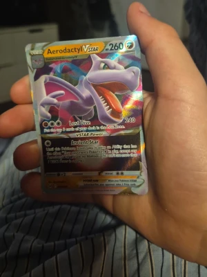 Aerodactyl VSTAR Pokémonkort - Jag e desperat för pengar okej. Säljer ett Aerodactyl VSTAR Pokémonkort med holografisk yta och färgstark design. Kortet har coola attacker som Lost Dive och Ancient Star. Perfekt för samlare eller dig som vill boosta din lek med ett kraftfullt kort.