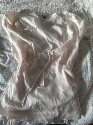 Ljusrosa satin topp från Gina Tricot - Jätte fin topp med justerbar snören för tajtare look om man vill och fina borderi blom detaljer 🌸använd en gång så i nyskick