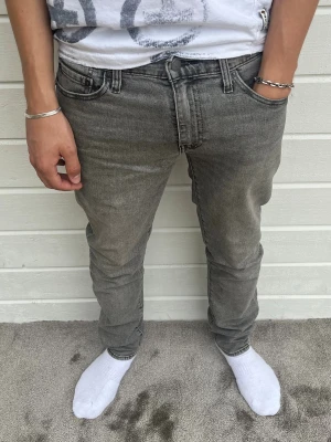 Levis 511 jeans grå - Hej, säljer dessa snygga grå levis jeans i nyskick. Modellen på bilden är 183cm och väger 68kg. Passformen är 511 (slim) och har storleken W30/L32. Inga defekter förekommer! Hör av dig! Mvh DC ♦️