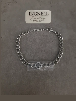 Ingnell Jewellery statement armband rostfritt stål – nytt - ✨ Effektfullt armband från Ingnell Jewellery Sweden i blankt rostfritt stål. Kraftigare kedjelänk med dekorativ detalj med klara stenar och en mörk sten i mitten.  📏 Längd ca 20 cm 🔗 Justerbar med förlängningskedja 🧵 Rostfritt stål – nickelsäkert  ✨ Helt nytt och oanvänt. Skyddsfilmen sitter kvar på detaljen.  📦 Presentationskortet på bilderna ingår inte. Packas omsorgsfullt inför frakt.