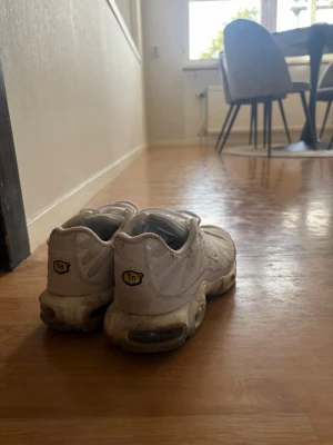 TN Nike Airmax - Säljer ett par vita Nike Air Max Plus sneakers med mesh- och syntetmaterial. Skorna har den klassiska TN-loggan på hälen och synliga Air-enheter i sulan. Snyggt vågmönster på ovandelen och lågt skaft för en clean look.