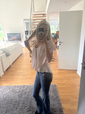 Blå bootcut jeans med broderad ficka - Säljer ett par blå bootcut jeans med snygga broderade detaljer på bakfickan. Jeansen har klassisk femficksmodell och normal midja. Perfekta för dig som vill ha en avslappnad men ändå trendig look.