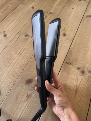 Remington plattång bred modell - Säljer en bred plattång från Remington i svart och silver. Perfekt för att snabbt styla och räta ut håret. 