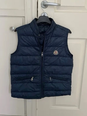 Moncler gui ÄKTA - Säljer denna riktigt feta västen från Moncler | Skick: 9/10 (som ny) | Den är i storlek 14 men sitter som xs | Nypris: Nästan 10 000kr | Kom PM för fler frågor eller äkthetsbevis📩 | Vill bli av med den fort så först till kvarn!