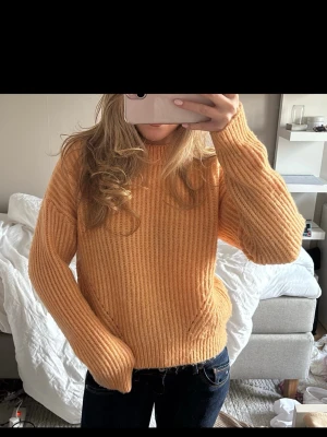 Stickad tröja i aprikos färg - En snygg stickad tröja i aprikos färg med ribbad struktur och rund hals💕Den är lite nopprig men inga andra defekter 💕