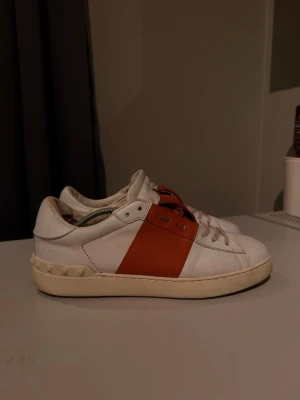 Valentino open - Ett par valentino open skor med en snygg vit/orange färg, skorna är i bra skick men har tecken på användning. Sulan har blivit lite mörkare i färgen annars är självaste skorna i ett extremt bra skick och har inga andra skador, märken eller defekter, vill man så kan man använda lite vit skofärg på sulan så ser dem nya ut igen. Storlek 42, självklart 100% äkta (se bild 5) nypris på dessa är 6799:- mitt pris är endast !?899:-?!, inga tillbehör medföljer vid köp. Hör av dig vid intresse!🤩