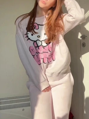 Ljusrosa Hello Kitty sweatshirt - Söt ljusrosa sweatshirt med stort Hello Kitty-tryck framtill och texten 'Hello Kitty' i rosa. Tröjan har rund halsringning och långa ärmar. I storlek xs, lite använd. Från new Yorker, har inga hål eller fläckar.