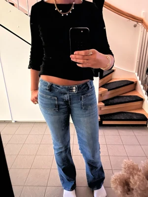 Blå bootcut jeans med fickor fram - Säljer ett par mörkblåa jeans med relativ låg midja och bootcut passform. sitter jätte bra och åker inte ner när man går. helt enkelt inte längre min stil. Pris kan absolut diskuteras!