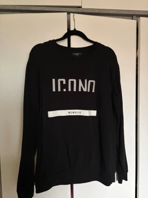 Svart sweatshirt med tryck ICONO - Cool svart sweatshirt med vitt tryck där det står ICONO MILANO.