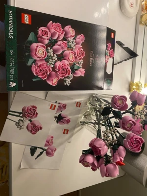 LEGO Botanicals Pink Roses set - Säljer ett LEGO Botanicals Pink Roses set med rosa rosor och vita detaljer. Setet innehåller flera byggda blommor i plast med gröna stjälkar och blad. Perfekt som dekoration eller present till någon som gillar LEGO och blommor. Instruktionsböcker och originalkartong medföljer. Ingenting saknas.