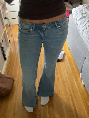 Ljusblå bootcut jeans ONLY - Säljer ett par slutsålda ljusblå bootcut jeans från ONLY med klassisk femficksdesign och väldigt låg midja. Jeansen har utsvängda ben och är tillverkade i mjukt denimtyg. Storleken är W27x32