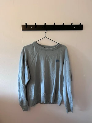 Ljusblå oversized sweatshirt - En ljusblå  sweatshirt från Acne med rund halsringning och ribbade muddar vid ärmslut och nederkant. Är sparsamt använd. 
