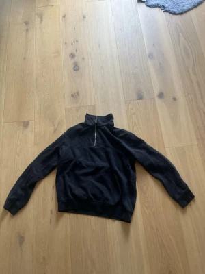 Svart halfzip hoodie - En svart hoodie med halv dragkedja och hög krage.Materialet är mjukt och bekvämt, perfekt för en avslappnad stil. Klassisk och enkel design. Pris kan diskuteras.